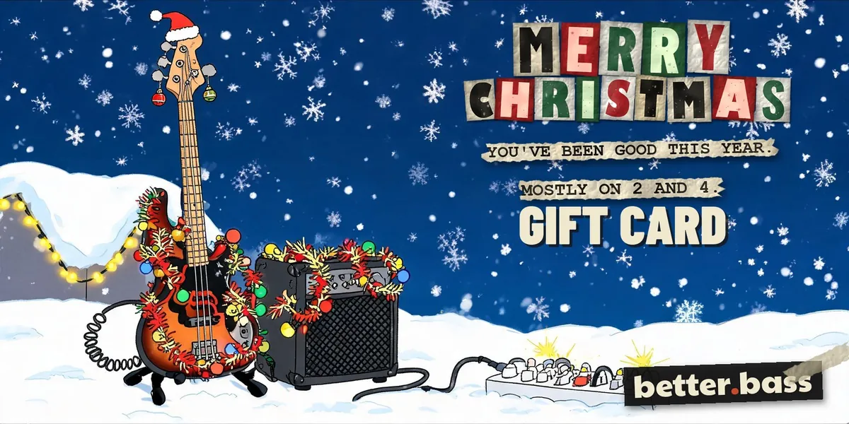 Better Bass Lessons Holiday gift card: a cartoon electric bass wrapped in Christmas lights next to an amp in the snow, with Merry Christmas in cut-out letters
